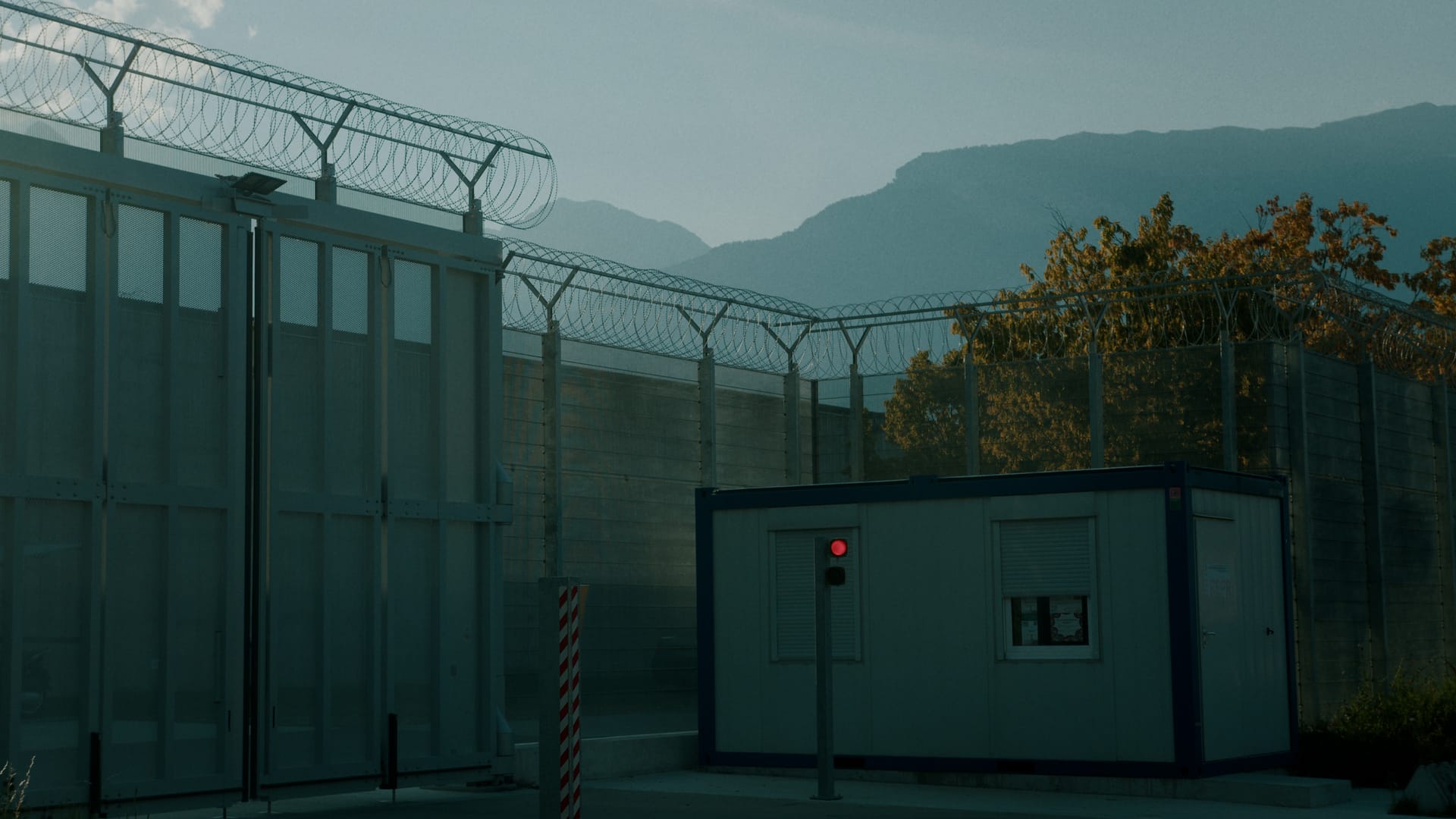Umfassungsmauer, Tor und Wachposten einer Justizvollzugsanstalt.