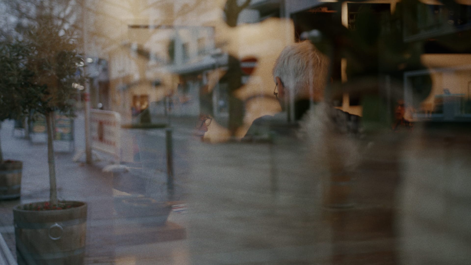 Eine Strassenszene spiegelt sich in einem Schaufenster.